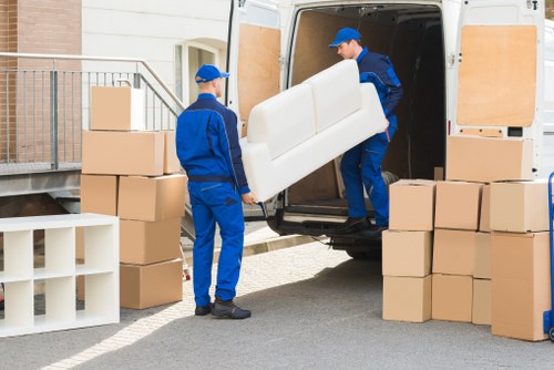 Professional removals crew loading boxes and furniture into a van